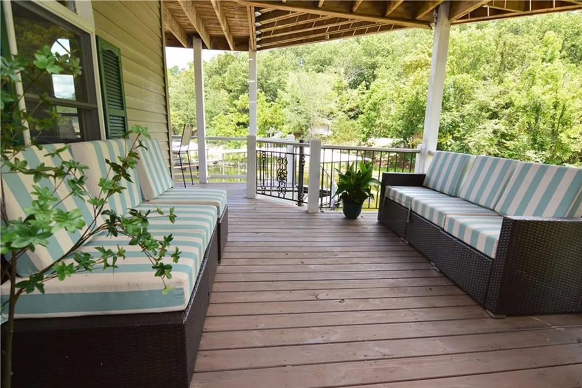 This image spotlights striped outdoor sofas arranged on a wooden deck, accented by a planter with greenery. The tranquil setup conveys a cozy, comfortable atmosphere ideal for lounging or entertaining while soaking up the outdoor ambiance.